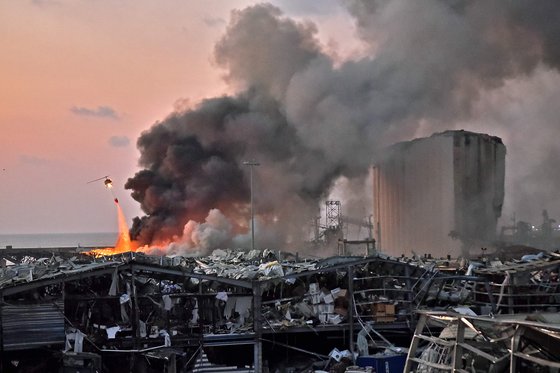 지난 8월 4일(현지시간) 대규모 폭발 사고가 발생한 레바논 베이루트 항구에서 소방 헬기가 진화 작업을 벌이고 있다. AFP=연합뉴스