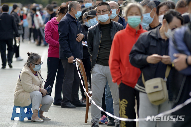 [칭다오=AP/뉴시스]12일(현지시간) 중국 산둥성 동부의 칭다오 주택가 인근에서 코로나19 확산 예방을 위해 마스크를 쓴 주민들이 코로나19 검사를 받기 위해 줄 서서 기다리고 있다. 중국 정부는 칭다오 병원의 한 병원에서 코로나19 집단 감염이 발생해 인구 1천만 명에 달하는 전 주민에 대해 코로나19 검사를 한다고 밝혔다. 2020.10.12.