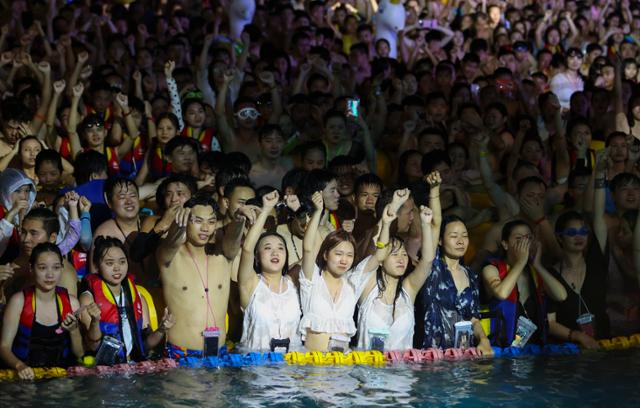 8월 중국 후베이성 우한시 마야비치 워터파크에서 수천명의 수영장 이용객들이 무대를 향해 손을 흔들며 DJ의 음악에 맞춰 파티를 즐기고 있다. 우한=EPA 연합뉴스