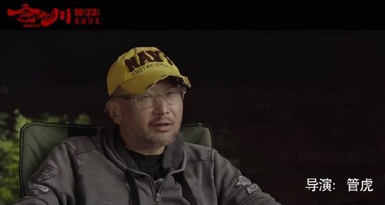 ‘항미원조’ 영화 ‘금강천’을 만든 감독 관후는 영화를 선전하는 자리에 ‘미 해군’이라 쓰인 모자를 쓰고 나왔다가 중국 네티즌으로부터 뭇매를 맞았다. [중국 텅쉰망 캡처]
