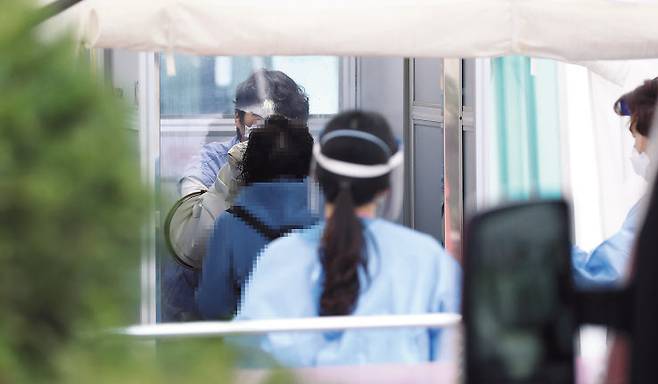 28일 서울 국립중앙의료원 코로나19 선별진료소에서 한 시민이 검사를 받고 있다. 중앙방역대책본부는 이날 0시 기준으로 신규 확진자가 103명 늘었다고 발표, 지난 26일(119명) 이후 이틀 만에 다시 세자릿수를 기록했다. [연합]