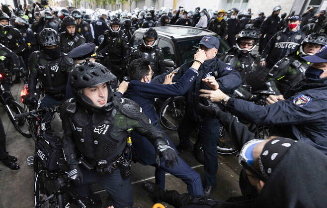 미국 뉴욕 경찰이 1일(현지시각) 트럼프 지지자들의 자동차 퍼레이드를 막으러 나온 시위대 중 한명을 체포하고 있다. 뉴욕/EPA 연합뉴스