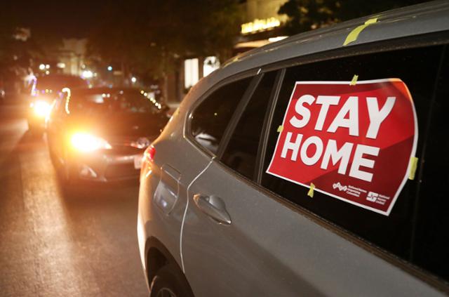 미국 텍사스주 앨패소에서 16일 한 차량이 '집에 머물라' 는 표지판을 붙인 채 코로나19 확산 방지에 동참할 것을 호소하고 있다. 앨패소=게티이미지·'AFP 연합뉴스