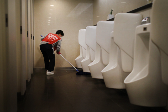 ▲ LG트윈타워 청소 노동자가 새벽에 출근해 화장실 바닥을 닦고 있다. ⓒ프레시안(최형락)