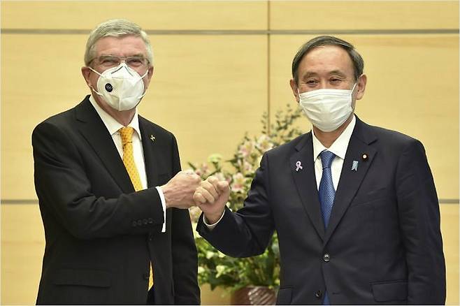 바흐 IOC 위원장과 '주먹 인사' 나누는 스가 일본 총리. (사진=연합뉴스)