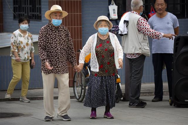사진은 중국 베이징의 한 공원에서 마스크를 쓴 노부부가 손을 잡고 산책하고 있는 모습.베이징 AP 연합뉴스