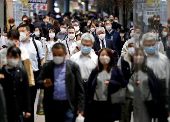 지난 19일 도쿄의 한 중심가. 코로나19 감염을 우려해 마스크를 쓴 인파가 거리를 가득 메우고 있다. 로이터 뉴스1