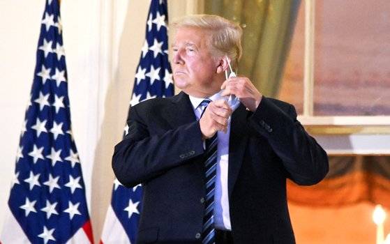 도널드 트럼프 미국 대통령이 지난달 5일 코로나19로 입원한 지 72시간 만에 퇴원해 백악관으로 돌아와 마스크를 벗고 있다. 입원 당시 트럼프 대통령은 리제네론이 개발한 단일 클론 항체로 치료를 받았다. 로이터=연합뉴스