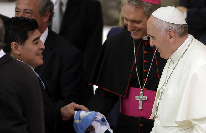 프란치스코(오른쪽 첫 번째) 교황이 지난 2014년 디에고 마라도나(왼쪽 첫 번째)를 만나 이야기를 나누고 있는 모습. [AP]