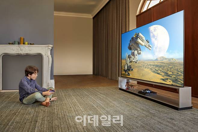 LG전자 모델이 ‘LG 올레드 TV’로 게임을 즐기고 있다. (사진=LG전자)