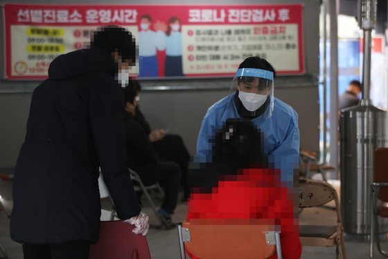 6일 오후 서울 동작구 보건소에 마련된 선별진료소에서 의료진이 검사를 받으러 온 시민의 상태를 확인하고 있다. 연합뉴스
