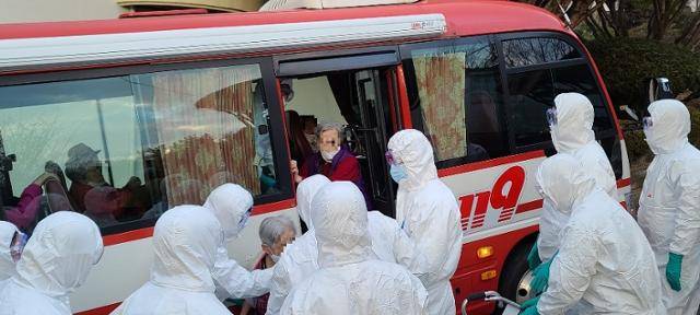 충남 공주보건소 직원들이 푸르메요양병원의 경증 입원환자들을 임시 격리시설인 공주유스호스텔로 이송하고 있다. 이 요양병원에서는 51명의 환자가 발생했고, 확진자가 계속 발생하고 있다. 뉴스1