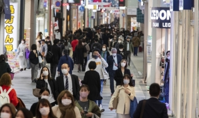 지난달 26일 마스크를 착용한 행인들이 오사카시의 한 쇼핑가를 지나가는 모습. AP/연합뉴스