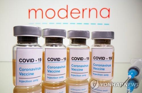 바이오 업체 모더나의 로고 아래 '코로나19 백신'이라고 쓰여진 약병이 놓여 있다. [로이터=연합뉴스 자료사진]