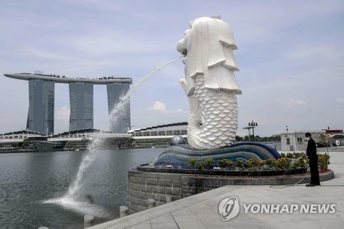 싱가포르 상징 멀라이언 동상(앞쪽)과 마리나 베이 샌즈 호텔(자료사진) [EPA=연합뉴스]