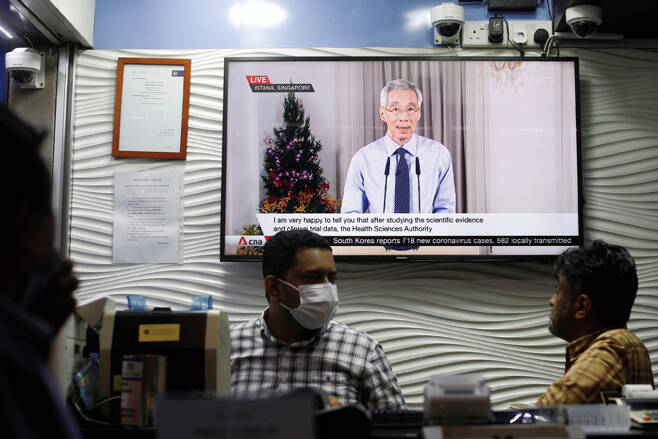12월14일 TV 스크린에 리셴룽 싱가포르 총리의 코로나19 백신 관련 대국민 연설이 방영되고 있다. ⓒREUTERS