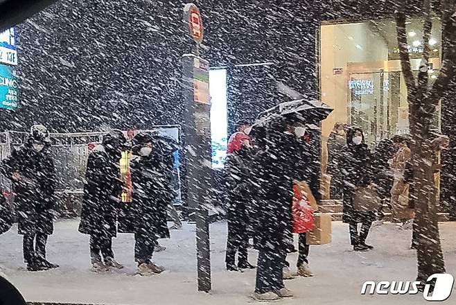 북극발 찬공기 영향으로 중부지역과 내륙을 중심으로 한파가 이어지고 있는 6일 저녁 서울 강남역 인근에서 시민들이 눈발을 맞으며 버스를 기다리고 있다.  2021.1.6/뉴스1 © News1 이동원 기자