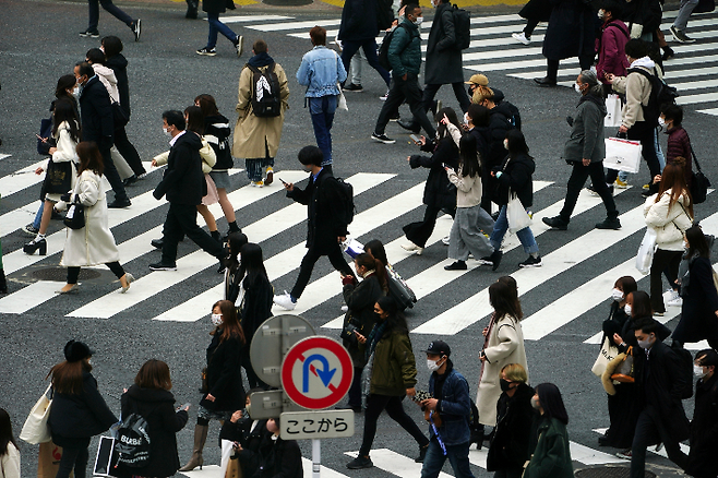 마스크를 쓴 사람들이 도쿄 시부야의 한 횡단보로를 걷는 모습. 연합뉴스