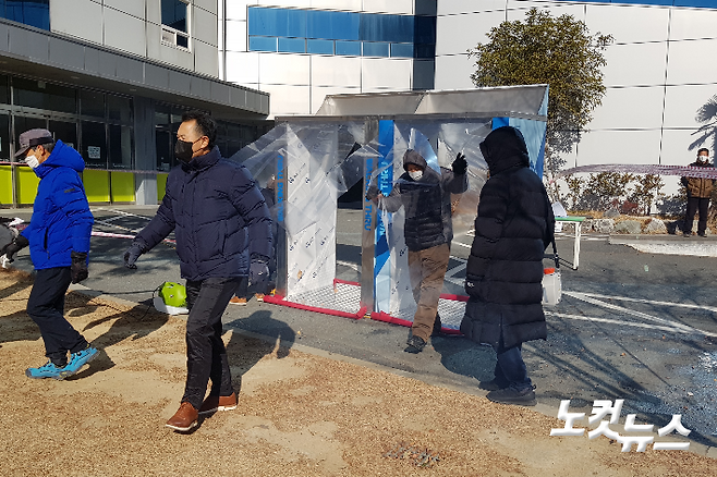 7일 부산 세계로교회 집회 참가자들이 워킹 스루 방식의 소독기를 통과하고 있다. 박진홍 기자
