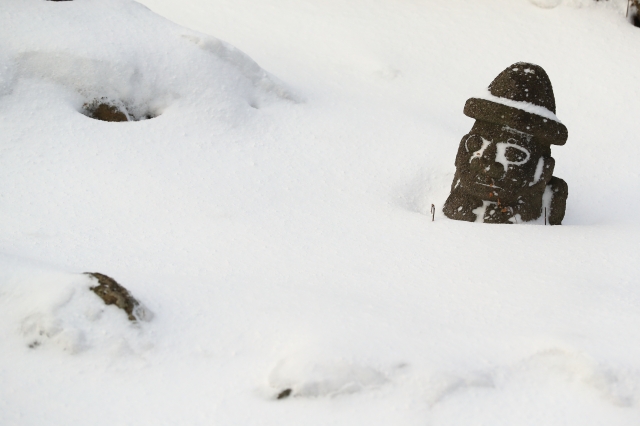 지난 7일 오전 516도로에 세워진 돌하르방이 눈에 파묻혀 있다. 연합뉴스