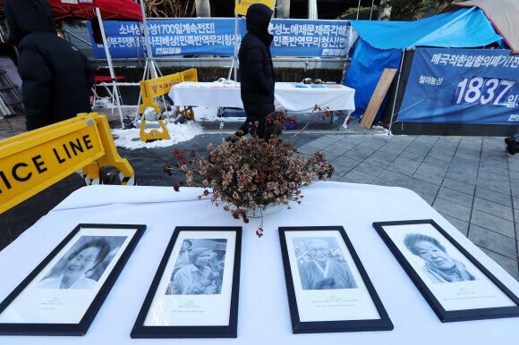 일본 정부가 일본군 ‘위안부’ 피해자들에게 배상해야 한다는 한국 법원의 판결이 나온 8일 서울 종로구 ‘평화의 소녀상’ 앞에 놓여 있던 피해자들의 사진. 연합뉴스