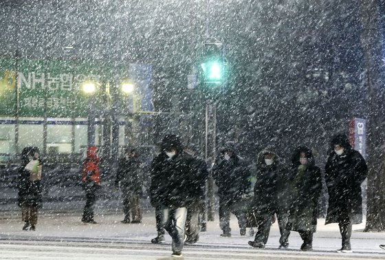 3~10cm의 많은 눈이 예보됐던 6일 오후 퇴근길 시민들이 서울 중구 시청 앞 횡단보도를 건너고 있다. 김성룡 기자
