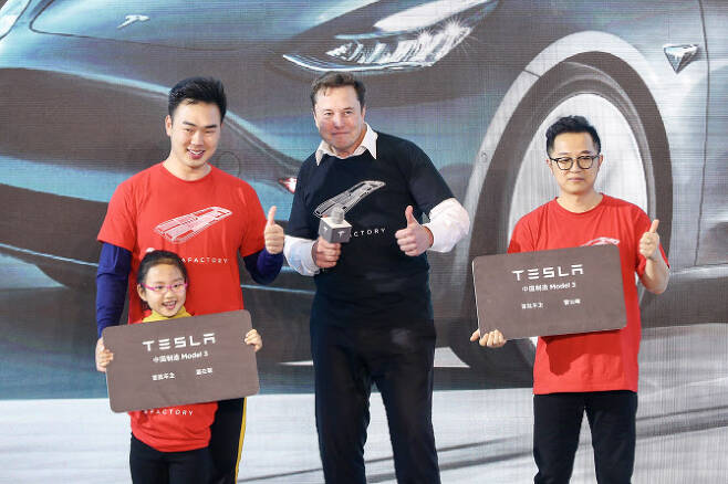 지난해 1월 7일 중국 상하이 테슬라 공장을 방문한 머스크가 모델3 구매자들과 포즈를 취하고 있다(사진=AFP)