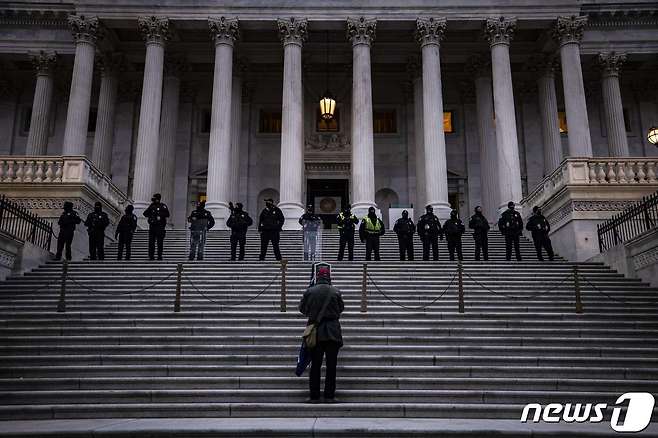 6일(현지시간) 워싱턴 의사당의 계단에 도열한 경찰 앞에 도널드 트럼프 미국 대통령을 지지하는 시위대가 서 있다. © AFP=뉴스1 © News1 우동명 기자