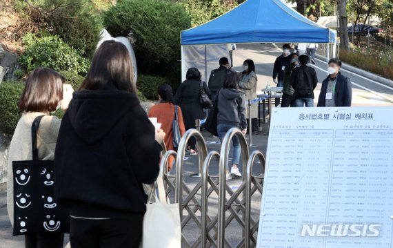 지방공무원 7급 공개경쟁 필기시험이 치러진 지난해 1월 서울 은평구 숭실 중·고등학교에 마련된 시험장에서 응시생들이 발열체크를 받으며 들어가고 있다. 뉴시스 제공
