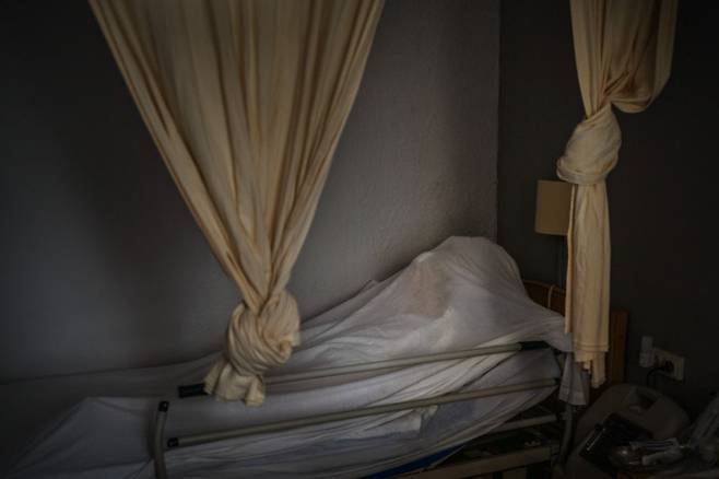 스페인 바르셀로나의 한 요양원에서 코로나19로 사망한 노인의 시신이 지난 11월13일 침대 위에 놓인 채 시트에 덮여져 있다. AP연합뉴스