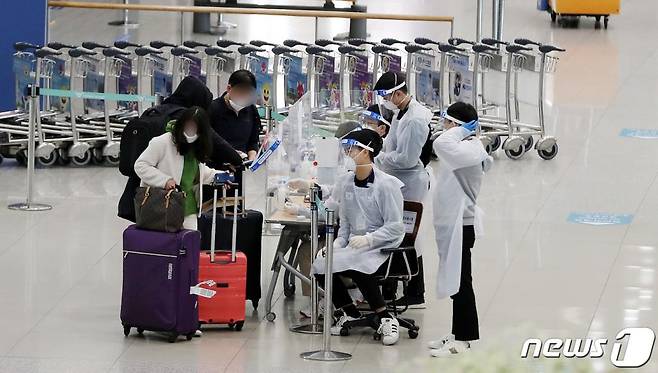 지난 6일 인천국제공항 입국장에서 방역 관계자들이 해외 입국자들에게 동선을 안내하고 있다. /사진=뉴스1