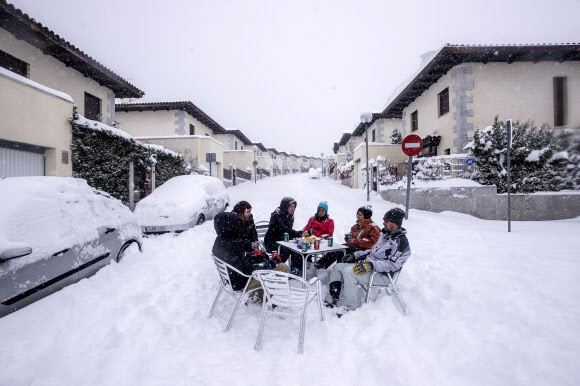 - 이웃들이 9일(현지시간) 스페인 마드리드 외곽의 부스타비조에서 폭설이 내리는 동안 거리 한복판에서 술을 마시고 있다. 지속적인 눈보라가 스페인의 많은 지역을 50년 동안의 기록적인 눈의 수준으로 뒤덮었다. AP 연합뉴스