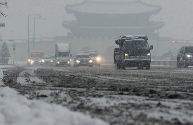 울 지역에 눈이 내린 12일 오후 서울 종로구 세종대로에서 차들이 눈길을 서행하고 있다. (사진=연합뉴스)