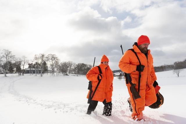 미국 위스콘신주에서 한 연인이 수렵총을 어깨에 매고 눈밭을 헤치며 사냥터로 걸어가고 있다. 윌스트리트저널 홈페이지