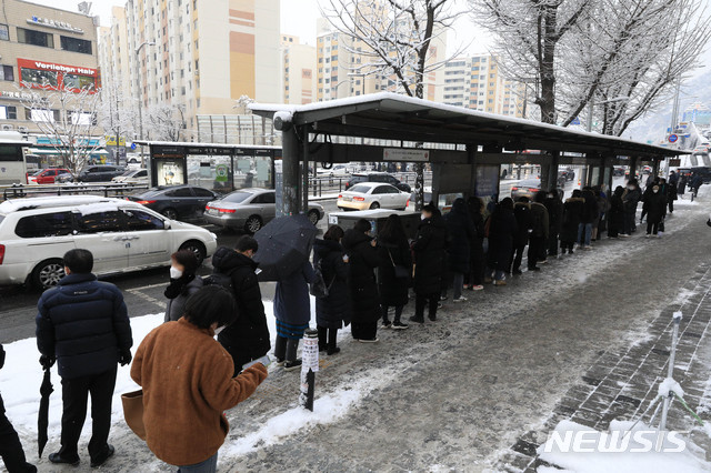 [서울=뉴시스] 박민석 기자 = 서울 지역에 눈이 내리고 있는 12일 오후 서울 동작구 사당역 인근에서 시민들이 버스를 탑승하기 위해 길게 줄을 서 있다. 2021.01.12. mspark@newsis.com