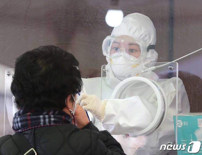 13일 서울역 광장에 마련된 임시선별진료소에서 의료진이 검체 채취를 하고 있다. 2021.1.13/뉴스1 © News1 이성철 기자
