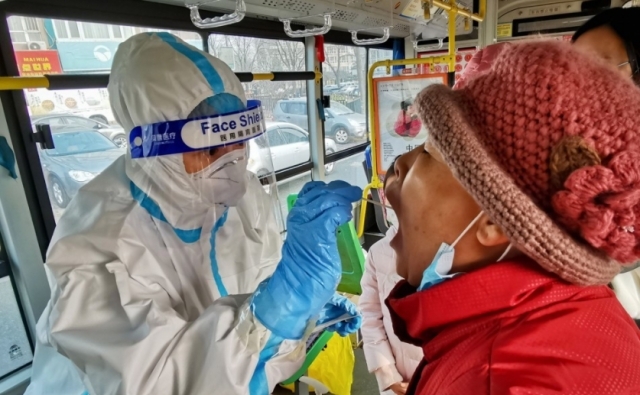 중국 다롄의 한 시내버스 안에서 코로나19 검사를 하는 모습. AFP 연합뉴스