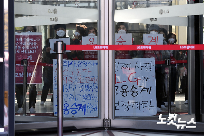 4일 오전 서울 여의도 LG트윈타워 로비에서 청소노동자들이 고용승계를 촉구하는 피켓을 들고 있다. 황진환 기자