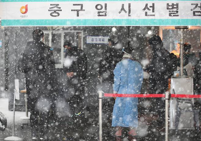 눈이 내린 12일 오후 서울역 광장에 마련된 코로나19 임시 선별검사소에서 시민들이 검사를 받고 있다. 연합뉴스