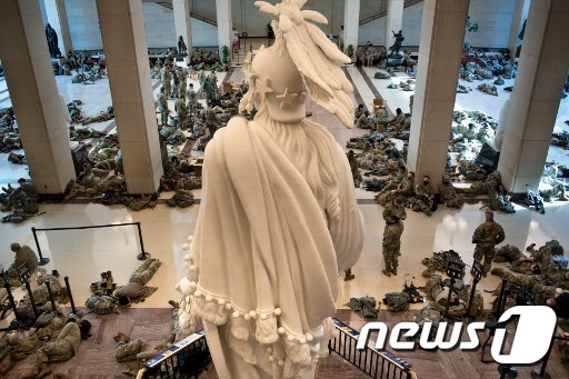 미국 주방위군 군인들이 연방의회 건물 안에서 휴식을 취하고 있다. © AFP=뉴스1