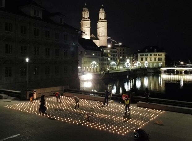 지난해 말 스위스 취리히 다리 위에서 시민들이 코로나19 희생자 추모 집회를 위해 촛불을 켜고 있다. /사진=로이터
