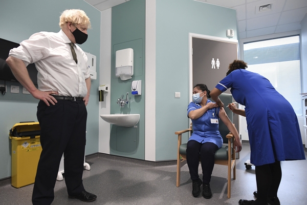 보리스 존슨(왼쪽) 영국 총리가 지난 4일(현지시간) 런던 북부의 체이스 팜 병원을 방문해 간호사가 아스트라제네카의 코로나19 백신을 주사하는 모습을 지켜보고 있다. AP 연합뉴스