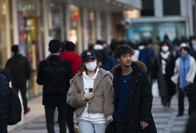 일본 정부가 코로나19 확산세를 꺾기 위해 긴급사태를 11개  지역으로 확대 발효한 가운데 도쿄의 한 거리에서 14일 한 시민이 마스크를 착용하지 않은 채 걷고 있다. AP 연합뉴스