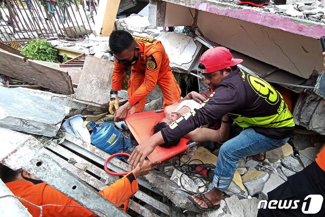 규모 6.2 강진이 발생한 인도네시아 웨스트술라웨시 마무주에서 구조대원들이 건물 잔해에 깔린 생존자를 구조하고 있다. © 로이터=뉴스1