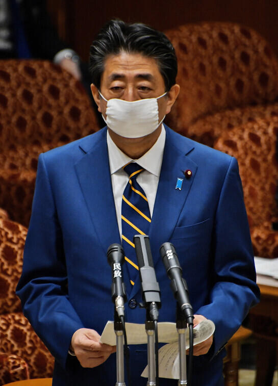 아베 신조 전 일본 총리가 이른바 ‘아베노마스크’를 쓰고 있는 모습. 코로나19 팬데믹에 늑장대응을 하다 뒤늦게 시작된 아베노마스크 정책은 국민의 외면과 비난을 받았다. UPI 연합뉴스