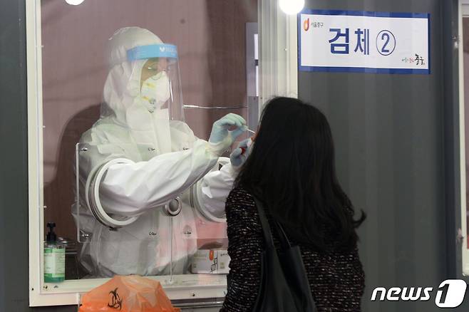 15일 오전 서울역 광장에 마련된 신종 코로나바이러스 감염증(코로나19) 임시선별진료소에서 시민이 검사를 받고 있다.2021.1.15/뉴스1 © News1 황기선 기자