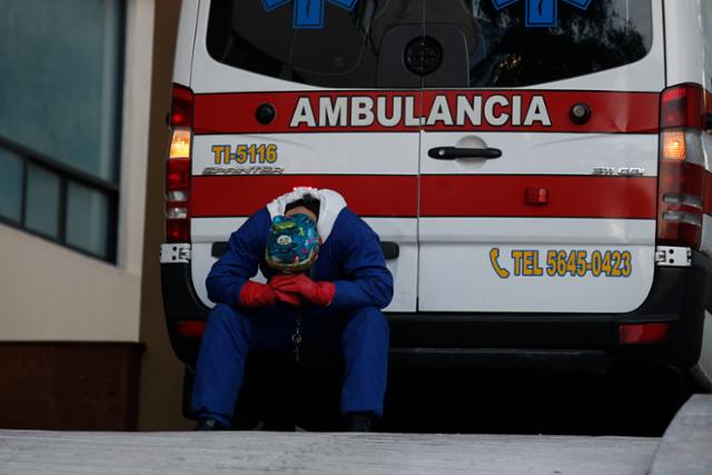 멕시코시티에 있는 Siglo XXI 메디컬 센터에 한 구급대원이 이송 환자의 입원수속이 수시간째 지연되자 엠뷸런스 뒤에 앉아 휴식을 취하고 있다. 멕시코시티=AP/뉴시스