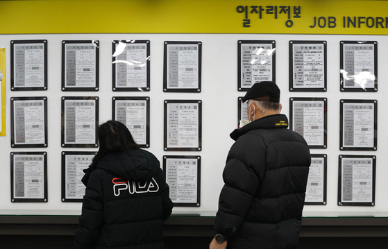 People looking at a job bulletin board at an employment and welfare center in Mapo District, western Seoul on Jan. 13. [NEWS1]