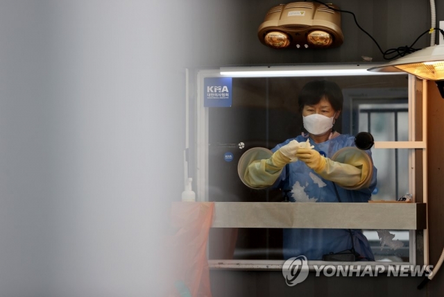 15일 서울시청 앞 마련된 임시선별진료소에서 의료진이 장갑을 갈아끼우고 있다. 연합뉴스
