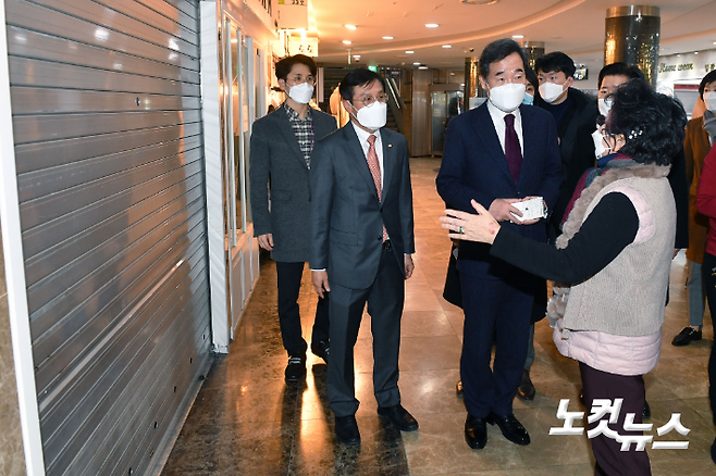 이낙연 더불어민주당 대표가 지난 14일 서울 영등포 지하상가 내 문을 닫은 상가 앞에서 상인들의 고충을 듣고 있다. 국회사진취재단